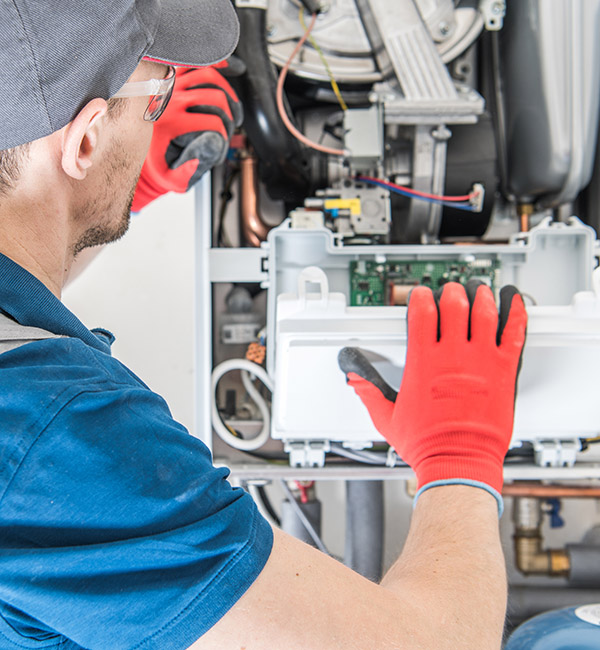 Technician repairing a gas furnace Technician repairing a gas furnace