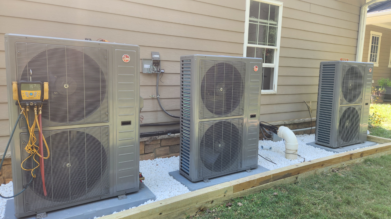 Central AC System Three heat pumps outside a home.