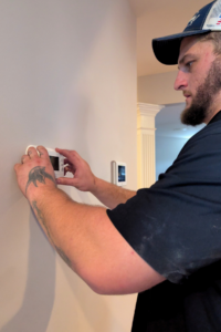 A technician installing a thermostat.