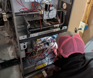 A Kasper Mechanical technician inspecting a furnace.