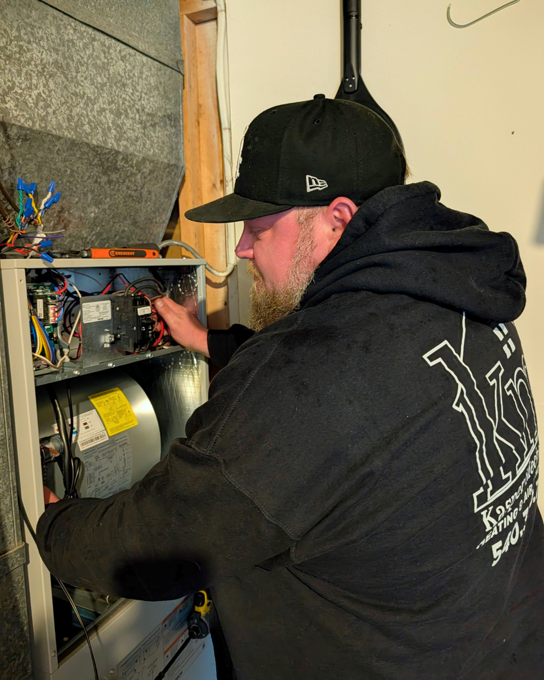 An HVAC technician servicing a furnace in King George VA.